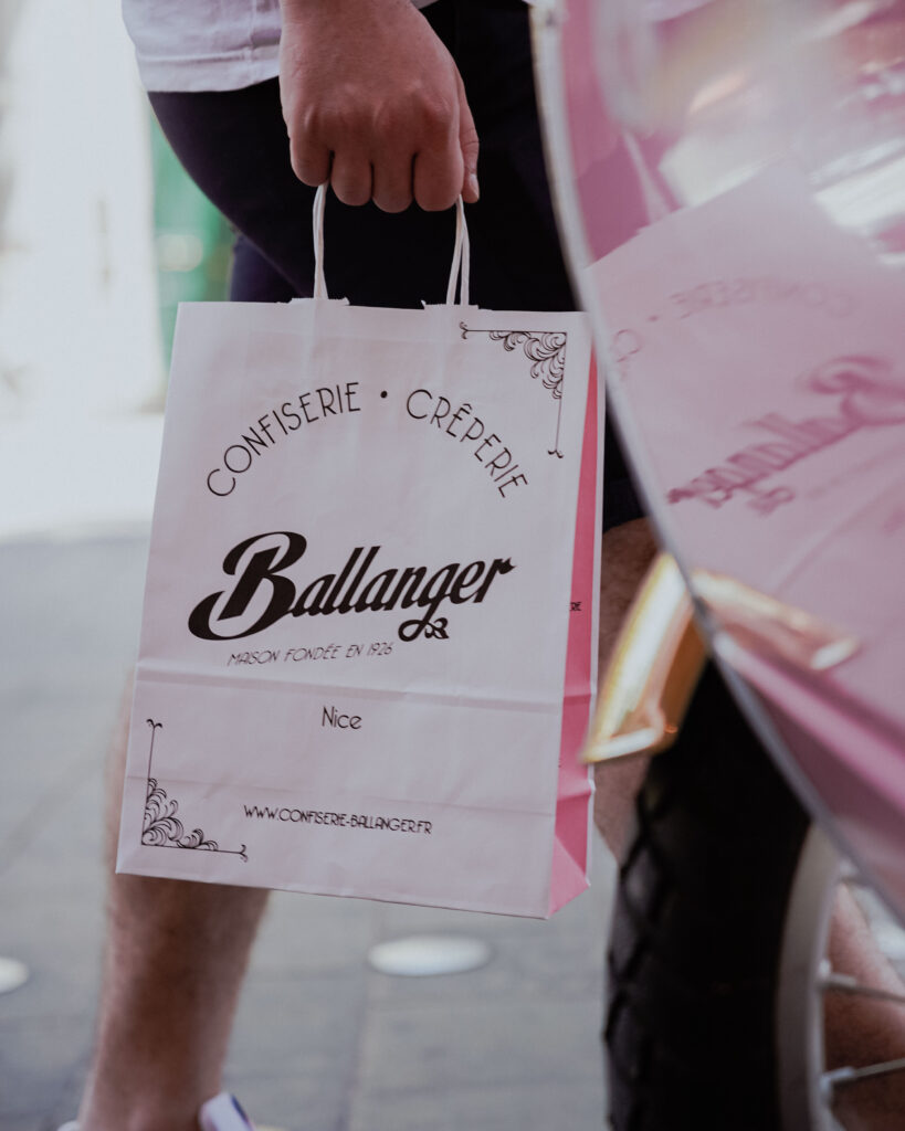 sac en papier rose, avec le logo de la maison Ballanger, tenue par une personne qui marche